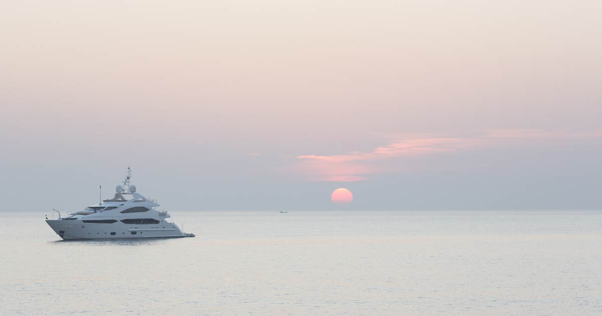 A Superyacht Sailing In Front Of The Rising Sun 