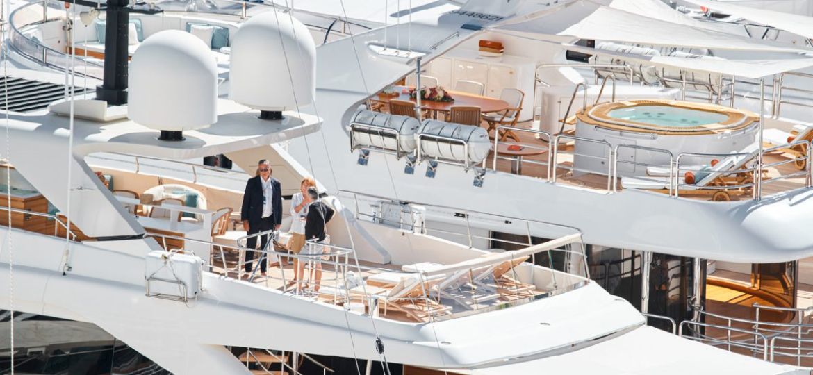 A small crowd engaged in conversation on a superyacht discussing a collaboration